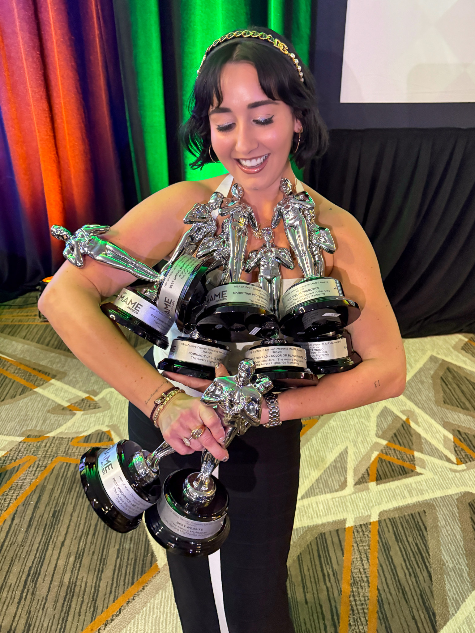 carlaferreira_managing-principal-carla-ferreira-poses-with-nine-mame-awards
